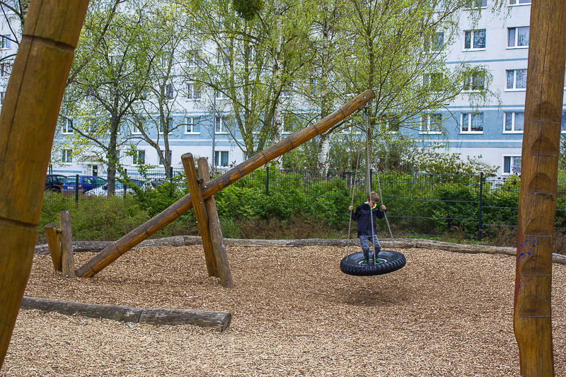 Im Hintergrund eines modernisierten Plattenbaus. Reifenschaukel-Spielplatz-Schweizer-Eck-Luebbenau-Spreewald.