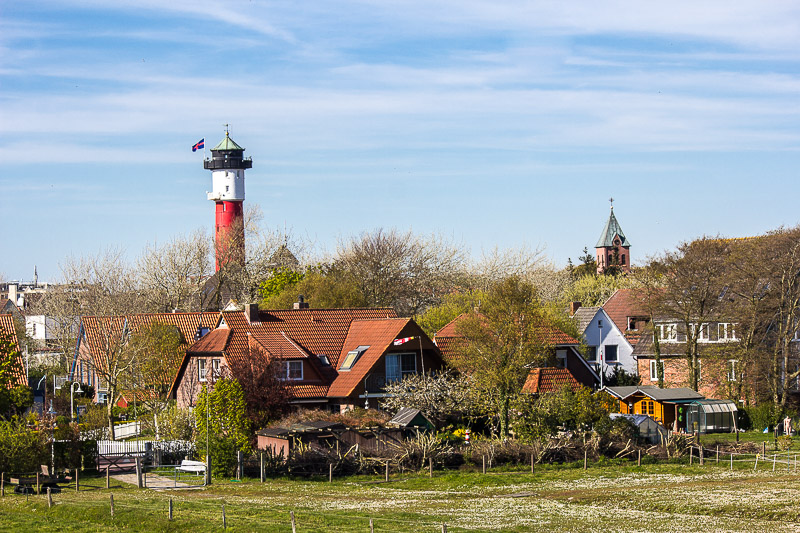 Schöne Aussichten beim Fahrrad fahren auf dem Deich. Dorf auf Wangerooge.